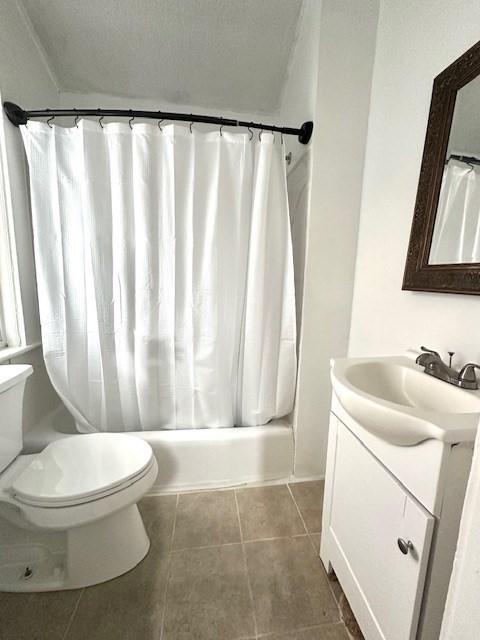 bathroom featuring toilet, shower / tub combo with curtain, vanity, and tile patterned flooring