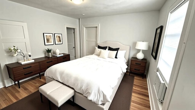 bedroom featuring multiple windows and wood finished floors