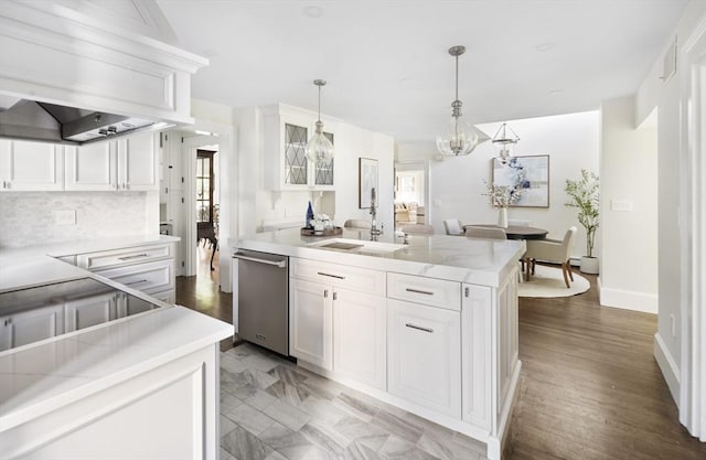 kitchen with white cabinets, pendant lighting, stainless steel dishwasher, and sink