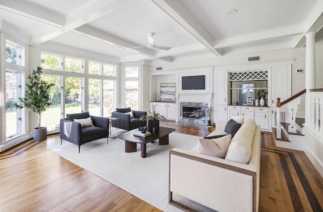 living room featuring beam ceiling, ceiling fan, and coffered ceiling