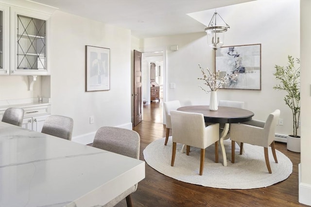 dining area with dark hardwood / wood-style flooring and a baseboard radiator