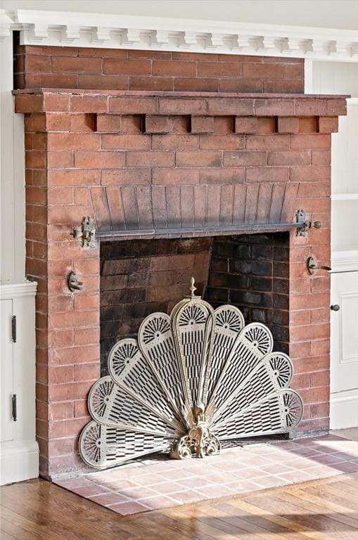 details with hardwood / wood-style floors and a brick fireplace