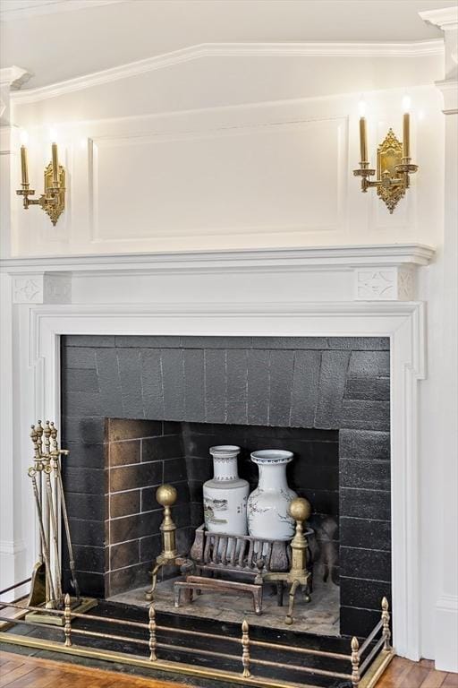 details with a tile fireplace, wood-type flooring, and ornamental molding