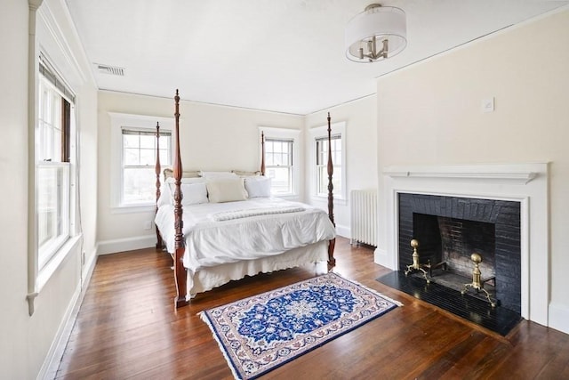 bedroom featuring radiator, crown molding, and dark wood-type flooring