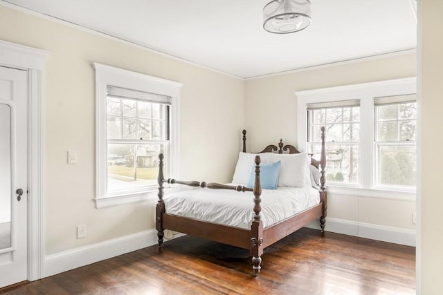 bedroom with dark hardwood / wood-style floors and crown molding