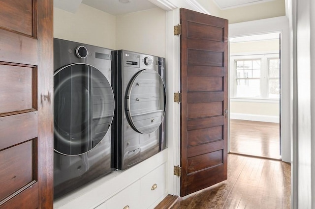 washroom featuring ornamental molding, washer and dryer, and hardwood / wood-style flooring