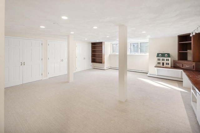 basement featuring light carpet and a baseboard heating unit