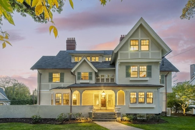 back house at dusk with a porch