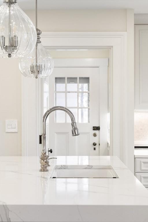 details featuring light stone countertops and sink