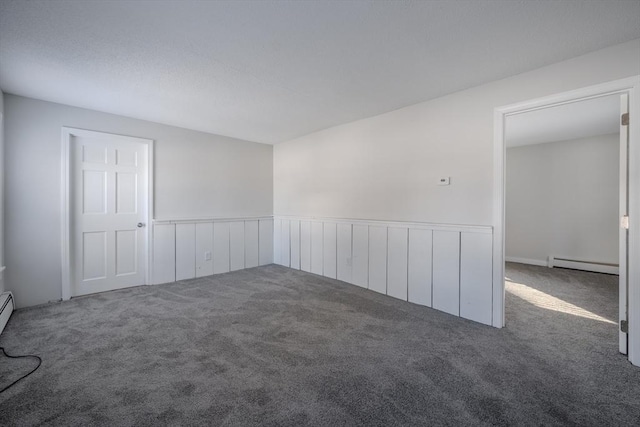 carpeted empty room with baseboard heating