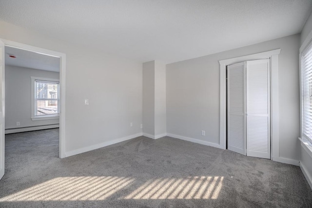 unfurnished bedroom featuring a baseboard radiator, a closet, and carpet