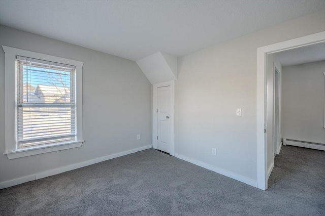 additional living space featuring a baseboard heating unit and carpet flooring