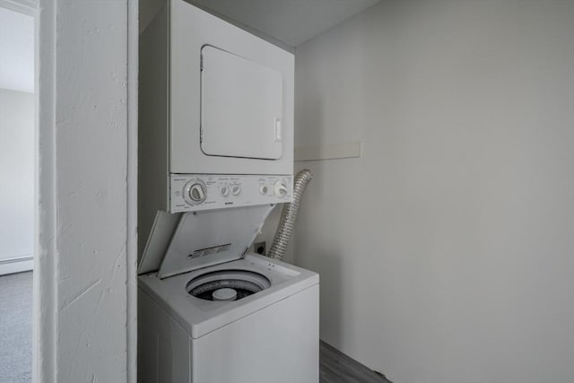 clothes washing area with stacked washer / dryer