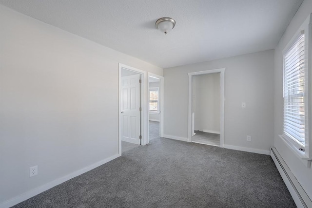 carpeted spare room featuring a baseboard radiator