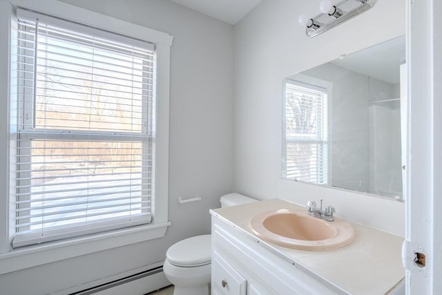 bathroom featuring vanity, walk in shower, toilet, and baseboard heating