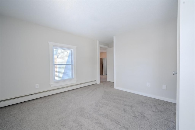 empty room with a baseboard heating unit and light colored carpet