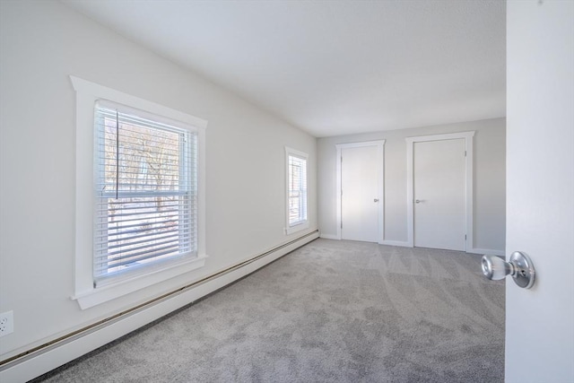 unfurnished bedroom with light carpet and baseboard heating