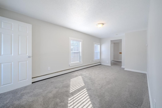 carpeted empty room featuring a textured ceiling and baseboard heating