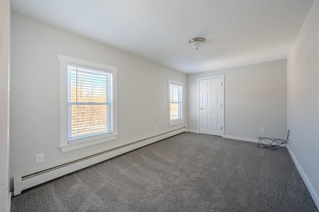 empty room featuring baseboard heating and carpet