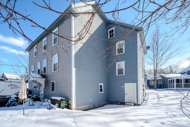 view of snow covered back of property