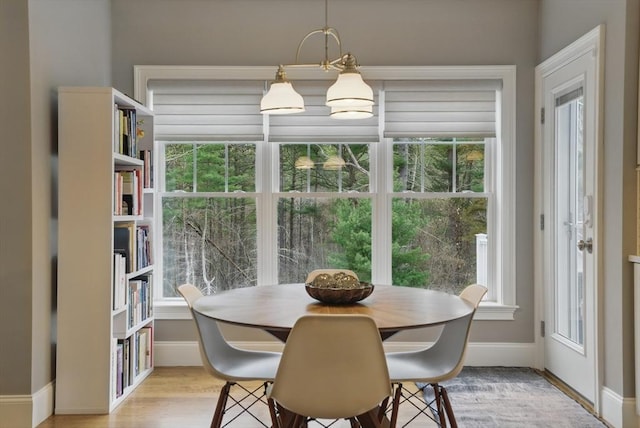 dining space featuring baseboards and light wood finished floors