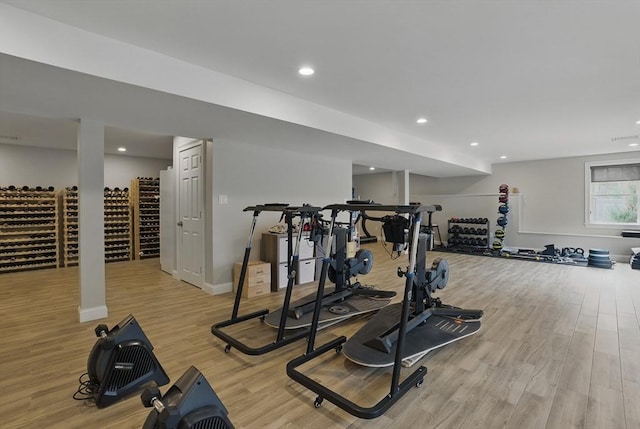 exercise area featuring recessed lighting, baseboards, and light wood finished floors