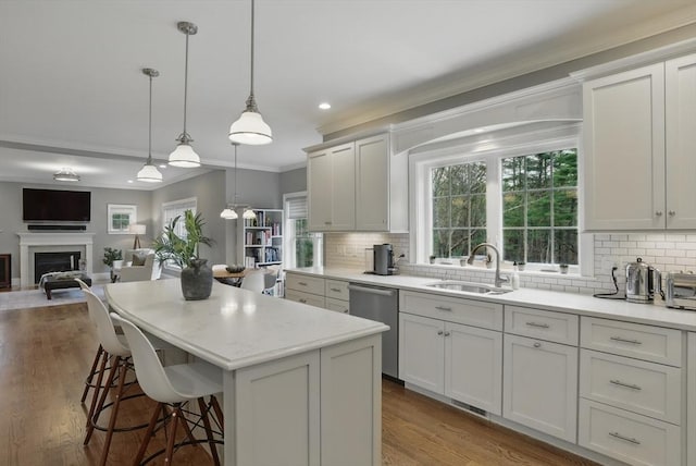 kitchen with ornamental molding, a sink, tasteful backsplash, and dishwasher