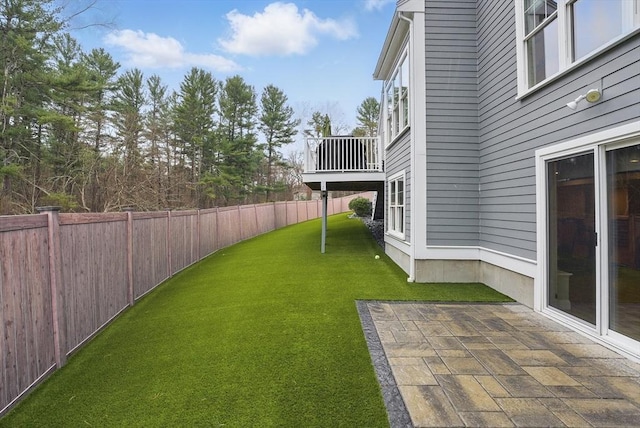view of yard with a fenced backyard, a patio area, and a balcony