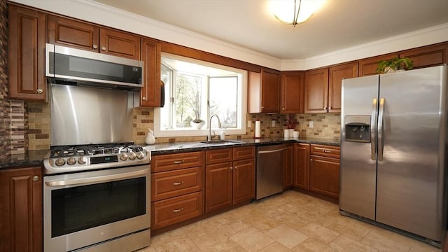 kitchen featuring decorative backsplash, stainless steel appliances, dark stone counters, and sink