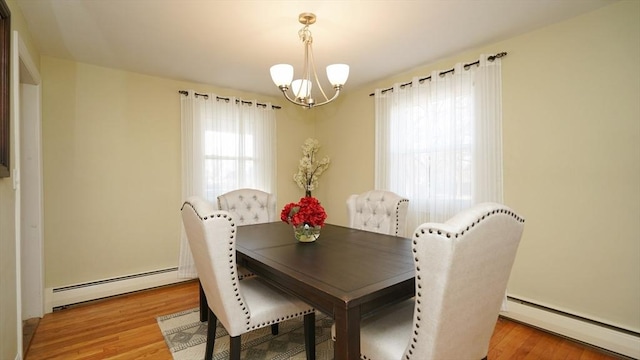 dining area with baseboard heating, a chandelier, and light hardwood / wood-style floors