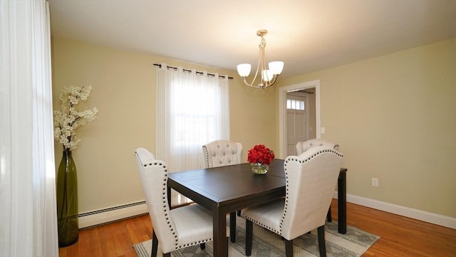 dining room with hardwood / wood-style flooring, an inviting chandelier, and a baseboard radiator