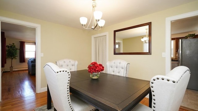 dining area with dark hardwood / wood-style flooring, baseboard heating, and a notable chandelier