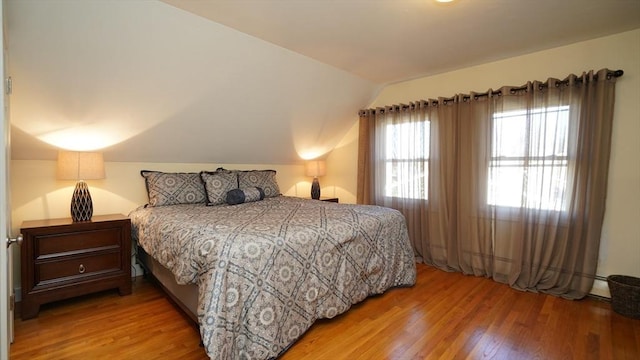 bedroom featuring hardwood / wood-style floors and vaulted ceiling