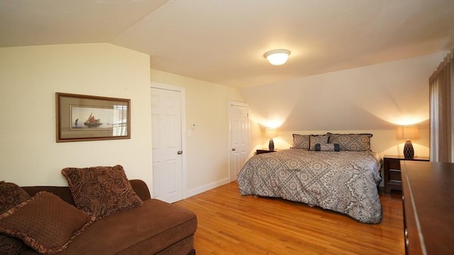 bedroom featuring hardwood / wood-style floors and lofted ceiling