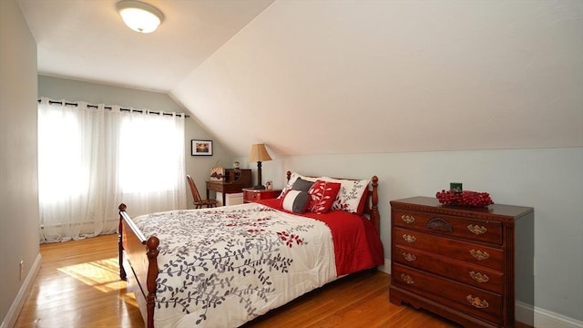 bedroom featuring wood-type flooring and vaulted ceiling