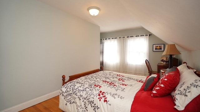 bedroom featuring wood-type flooring and vaulted ceiling