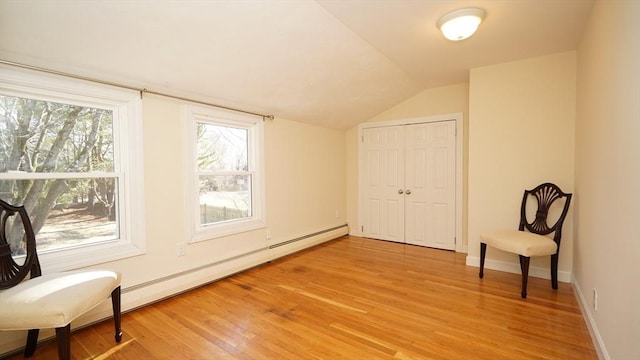 bonus room featuring light hardwood / wood-style floors, a baseboard radiator, and vaulted ceiling