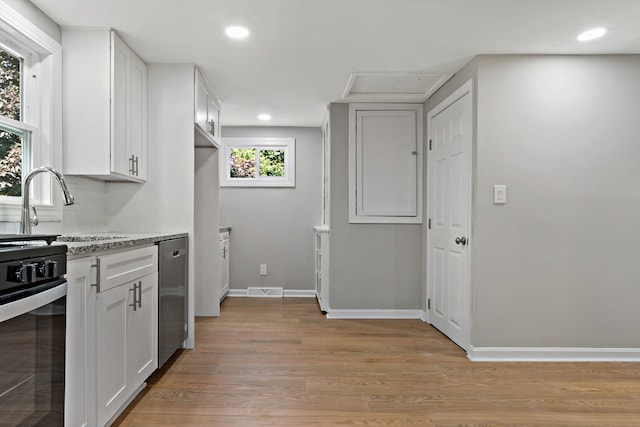 kitchen with range, white cabinets, and light hardwood / wood-style floors