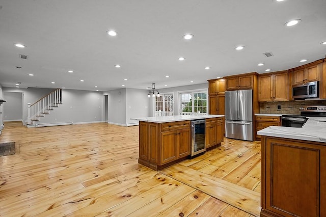 853 Oxford St S, Auburn, MA 01501 - kitchen with stainless steel appliances, wine cooler, light wood finished floors, brown cabinets, and recessed lighting