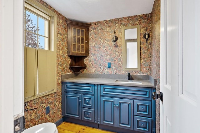 853 Oxford St S, Auburn, MA 01501 - half bath featuring wallpapered walls, vanity, toilet, and wood finished floors