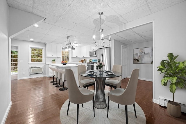853 Oxford St S, Auburn, MA 01501 - dining space featuring a drop ceiling, baseboards, a chandelier, dark wood finished floors, and a wall mounted air conditioner