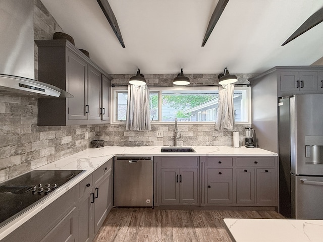 kitchen with dark hardwood / wood-style floors, sink, gray cabinetry, wall chimney exhaust hood, and stainless steel appliances