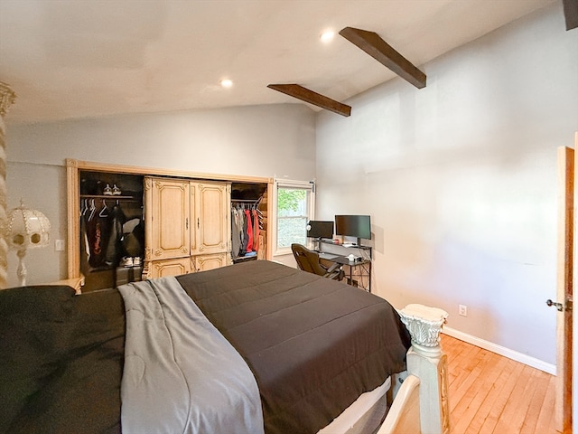 bedroom with vaulted ceiling with beams, a closet, and light wood-type flooring