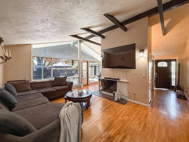 living room with hardwood / wood-style floors, lofted ceiling with beams, and plenty of natural light