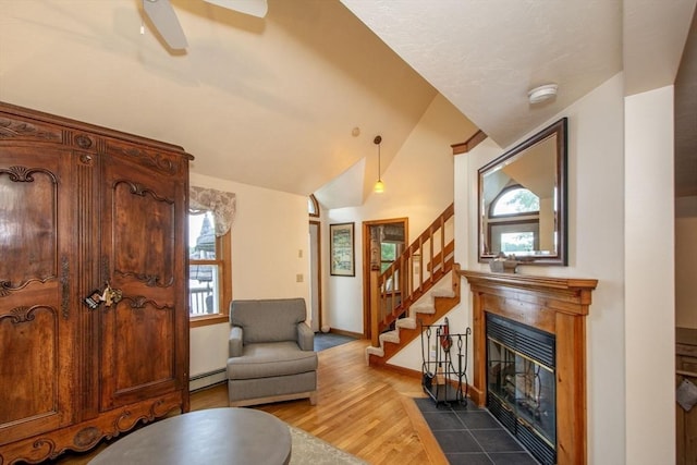 56 Carver St, Pembroke, MA 02359 - living room featuring a baseboard radiator, wood finished floors, lofted ceiling, stairway, and a fireplace with flush hearth
