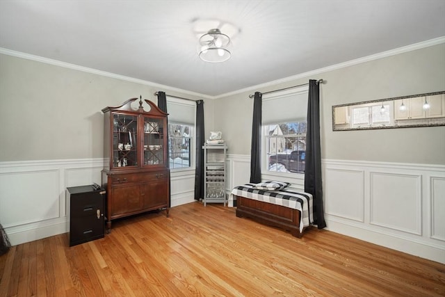 interior space featuring light wood finished floors, crown molding, and wainscoting