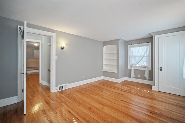 unfurnished bedroom featuring light wood finished floors, visible vents, and baseboards