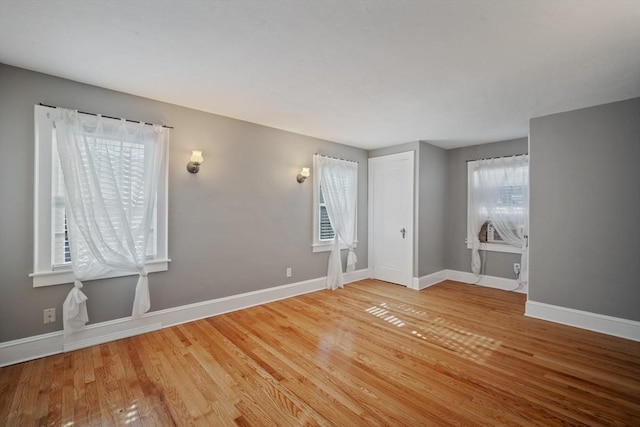 spare room with light wood-type flooring and baseboards