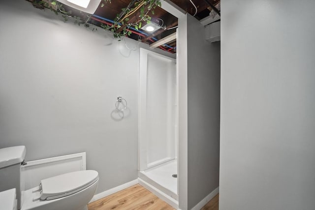 full bathroom with baseboards, a shower stall, toilet, and wood finished floors