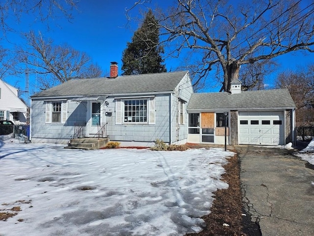 view of front of house with aphalt driveway, a chimney, an attached garage, and a shingled roof